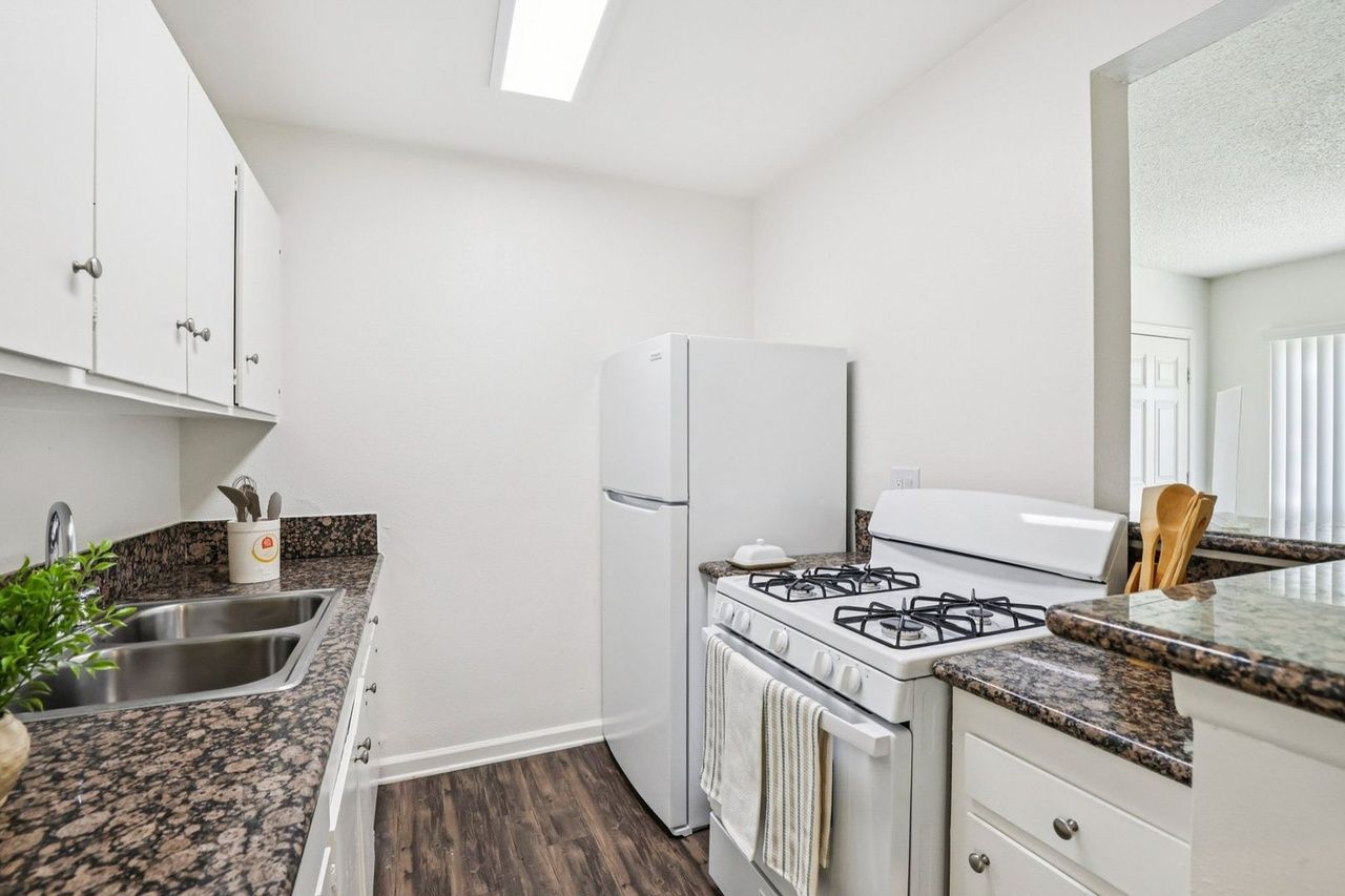 Dresden Place Apartments modern galley kitchen with granite style counters