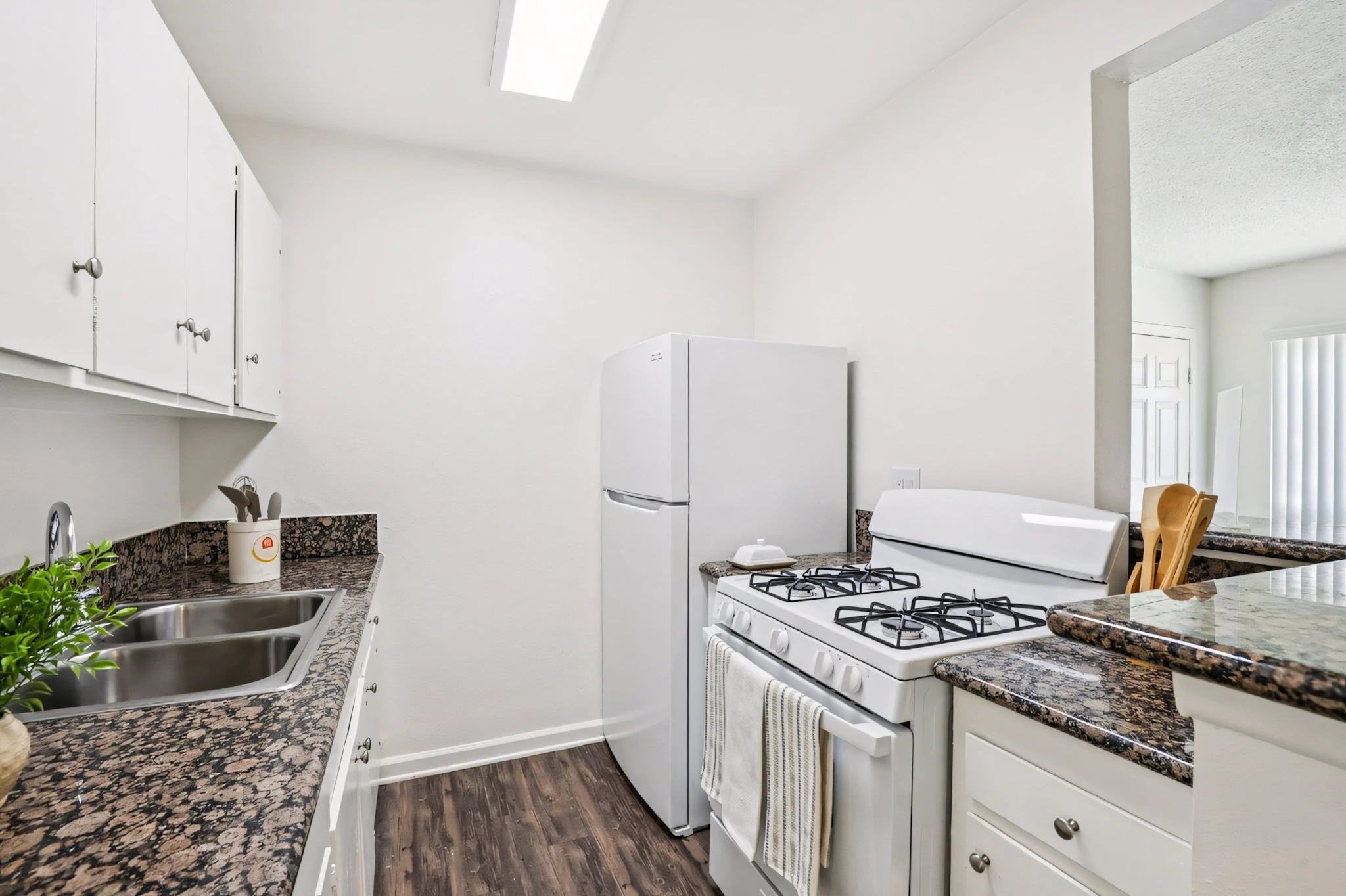 Dresden Place Apartments modern galley kitchen with granite style counters