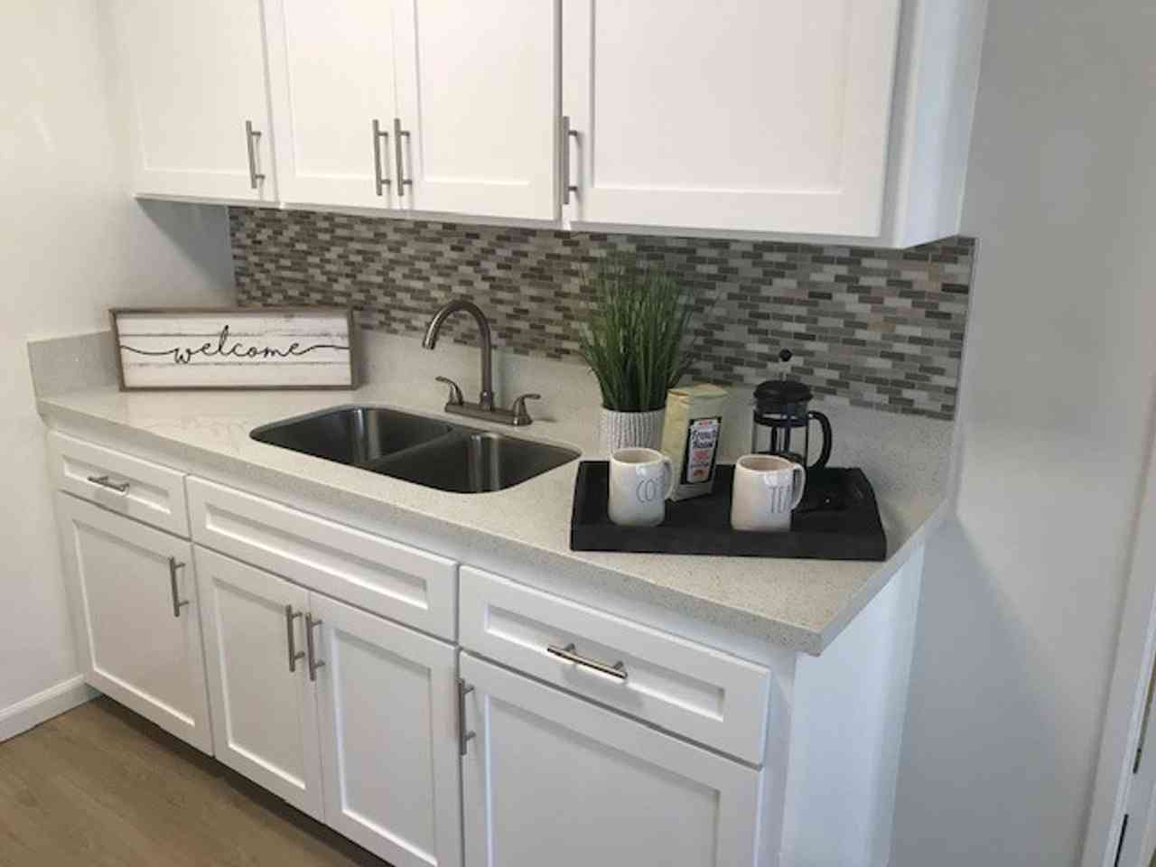 renovated kitchen sink and mosaic tile backsplash