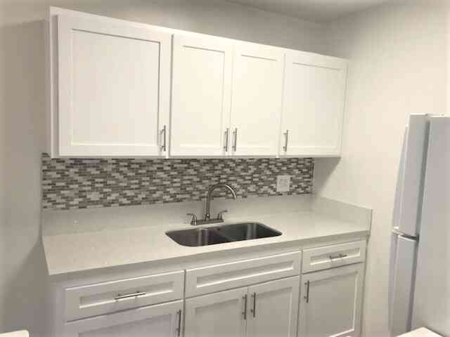 modern kitchen sink and white shaker cabinets